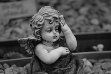 grayscale photography of a baby angel sculpture